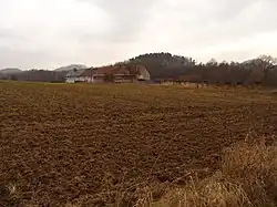 Pohled od severu na areál bývalého poplužního dvora s domy čp. 32, 33 a 40 v Břevništi, v jehož jižní části jsou zbytky tvrze