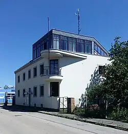 Dvoupatrová bílá budova s prosklenou nástavbou