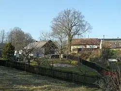 Stavení s dřevěným plotem, u stromu