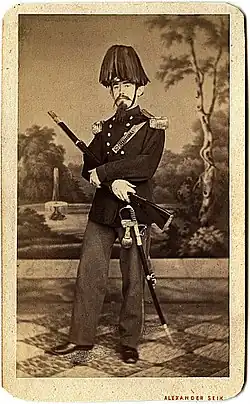 Řadový ostrostřelec s dvojrohým kloboukem s fedrpušem (chocholem z kohoutího peří), 1869.