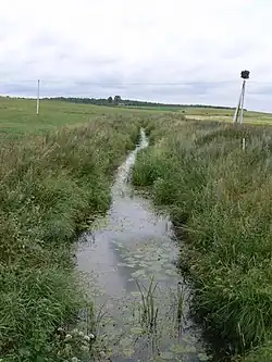 Pravý přítok Akmeny Šlaveita z ulice Dvaro g., Šlaveitai. Pohled po proudu, t.j. k jihovýchodu
