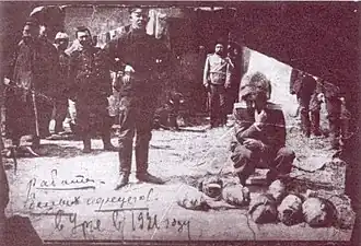 Důstojník bělogvardějců stojí vedle hlav popravených vězňů po obsazení věznice Gaming.