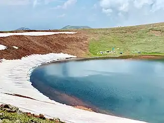 Turisté u bezejmenného jezera v kráteru