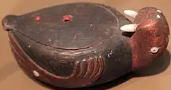 Hnědá dřevěná krabička kulatého tvaru s podobiznou mrože.