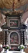 Bohatě zdobený hlavní oltář o třech etážích, uprostřed hlavní obraz s točenými sloupy po stranách, završení štítem s figurou Krista držící prapor
