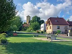 Náves s katolickým kostelem v pozadí