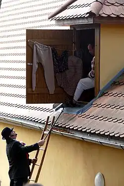 Kecal přemlouvá Pazderníka, aby slezl dolů z vikýře a vzal si Konopičku za ženu