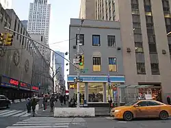 Budova 30 Rockefeller Plaza (vpravo) byla postavena kolem soukromého pozemku v severozápadním a jihozápadním rohu. Obchod Warby Parker uprostřed tohoto snímku nyní stojí na místě pozemku v severozápadním rohu 30 Rockefeller Plaza.