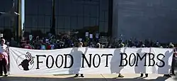Členstvo Food Not Bombs na protestech Occupy Wall Street ve Washingtonu D.C. v roce 2011. Mají velký transparent s nápisem Food Not Bombs