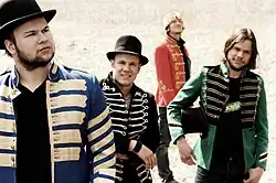 Fotka členů kapely 77 Bombay Street v jejich uniformách.