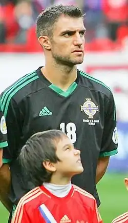 Aaron Hughes (v pozadí s dresem č. 18)