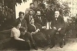 Rodinná fotografie pořízená na zahradě, sedící a stojící lidé