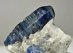 Krystal afghanitu v kalcitu společně s pyritem z typové lokality Sar-e-Sang