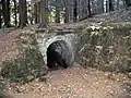 Portál zděné štoly, vedoucí k továrně