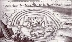 Černobílá rytina malé pevnosti s několika budovami obehnanými obdélníkovými hradbami s baštami uprostřed každé strany. Pevnost je ze tří stran obklopena trojitými valy obléhatelů na čtvrté, spodní straně je řeka, na řece na ostrově opevněný tábor obléhatelů jen o málo menší než pevnost.