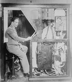 Vynálezce Anatol Josepho ve svém fotoautomatu Photomaton, asi 1927