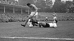 Horst Szymaniak (dole v bílém) v obranném zákroku proti nizozemskému útočníkovi Faas Wilkesovi roku 1959