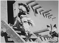 Dance, San Ildefonso Pueblo, Nové Mexiko, dva domorodci kmene Tewa v čelenkách stoupající po schodech do domu, 1941