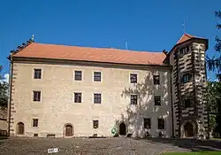 Pohled na jižní průčelí Horního zámku v Benešově nad Ploučnicí s polygonální schodišťovou věží.