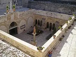 Ochoz nad ambitem, vzadu zeď kostela Narození Páně