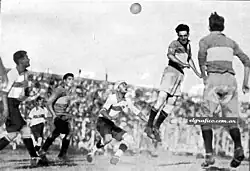 Evaristo jako hráč klubu Boca Juniors hlavičkující ve finále argentinské Primera División 1930 proti klubu Gimnasia