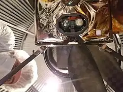 Vpravo člověk v bílém oblečení, lze vidět dvě čočky.