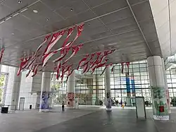 Pohled na jeden ze vstupů do knihovny a na přibližně padesát singapurských vlajek zavěšených ze stropu vždy po pěti. Dekorace k Národnímu dni Singapuru.