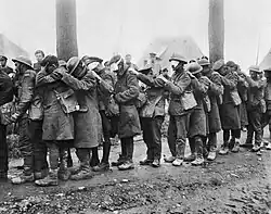 Řada oslepených britských vojáků držících se za ramena.