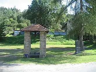 Zvonička, vedle ní křížek z roku 1909