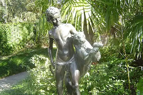 Na fotografie je sousoší chlapce a po jeho boku se ke skoku odrážejícího levharta.