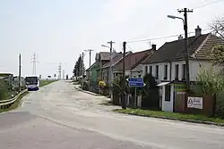 Zastávka autobusu, silnice a domy v centru vesnice