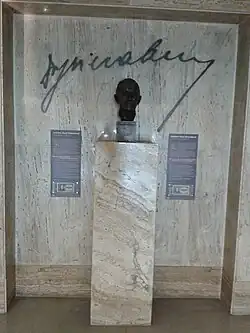 Celek (popisné tabulky, podpis, busta)