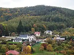 Střed Chabaní s točnou autobusu a dominantou chráněného sekvojovce obrovského