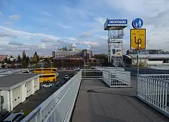 Pohled přes bezejmennou lávku překlenující dálnici D1 v Praze na Chodovci; vpravo prodejna Decathlon