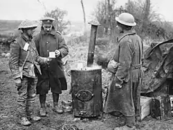 Západní fronta. (1. světová válka.) Místo první pomoci. Člen armádního zdravotnického sboru předává šálek kávy zraněnému vojákovi.
