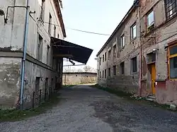 Ulička mezi opuštěnými průmyslovými objekty