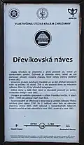 Dřevíkovská náves, stanoviště č. 10 vlastivědné stezky v sídelní lokalitě Dřevíkov, v obci Vysočina (informační tabule na návsi)