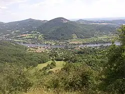 Pohled na Deblík od severozápadu, z návrší Skalky nad Dolními Zálezly. V pozadí vlevo Varhošť, vpravo Strážiště.