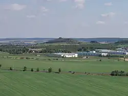 Pohled na Blšanský chlum od západu, před ním průmyslová zóna Louny – jihovýchod