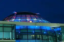 Barevná fotografie s pohledem na barevnou moderní budovu oblého tvaru