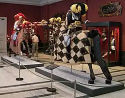 Barevná fotografie s pohledem na dva modely koňů v životní velikosti s figurínami jezdců v pestré zbroji