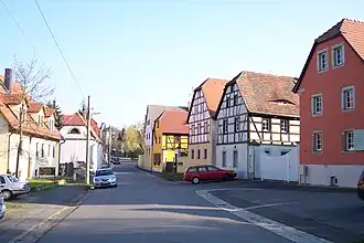 Barevná fotografie s pohledem na malebnou uličku s hrázděnými domy