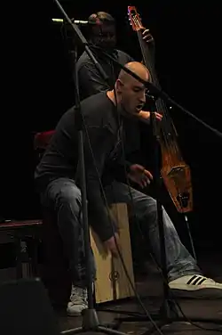 David Landštof hrající na cajón na dvojkoncertě skupin Garcia a Druhá tráva v Hradci Králové 18. dubna 2009