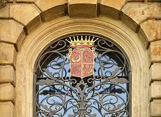 Ozdobná mříž okna se znakem Emanuela Pöttinga