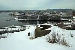 Výhled z Ekebergu na nově budovanou přístavní čtvrť Sørenga. V popředí pozůstatek patrně vidové hlásky.