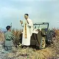 Otec Emil Kapaun sloužící mši svatou na kopotě jeepu (1950)