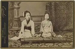 Dvě dívky hrají na strunný nástroj koto