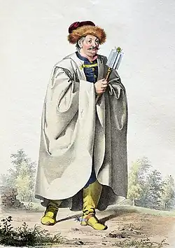 Muž s knírem, obalená bílým pláštěm. V roce drží žezlo.