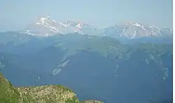 Pohled z vrcholu Ačišcho nad obcí Krasnaja Poljana na (zleva doprava) Fišt, Pšecho-Su (2854) a Oštěn (2804)