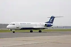 Fokker 100 v barvách Montenegro Airlines na mezinárodním letišti Domodědovo v Moskvě